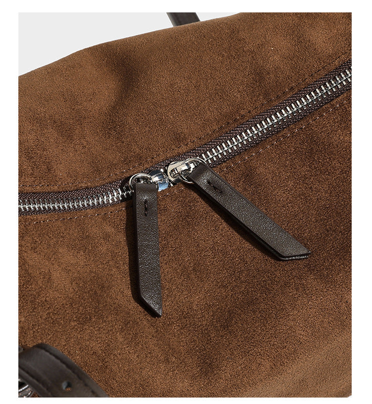 Large brown suede-finish barrel shoulder bag with dark leather-look trim, silver-tone zippers, dual top handles, and long