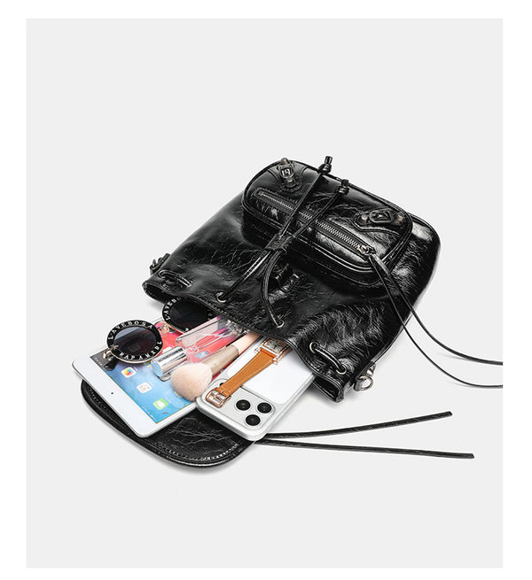 Small structured glossy leather-look convertible backpack handbag in black with flap closure, front zip pockets, metal stud
