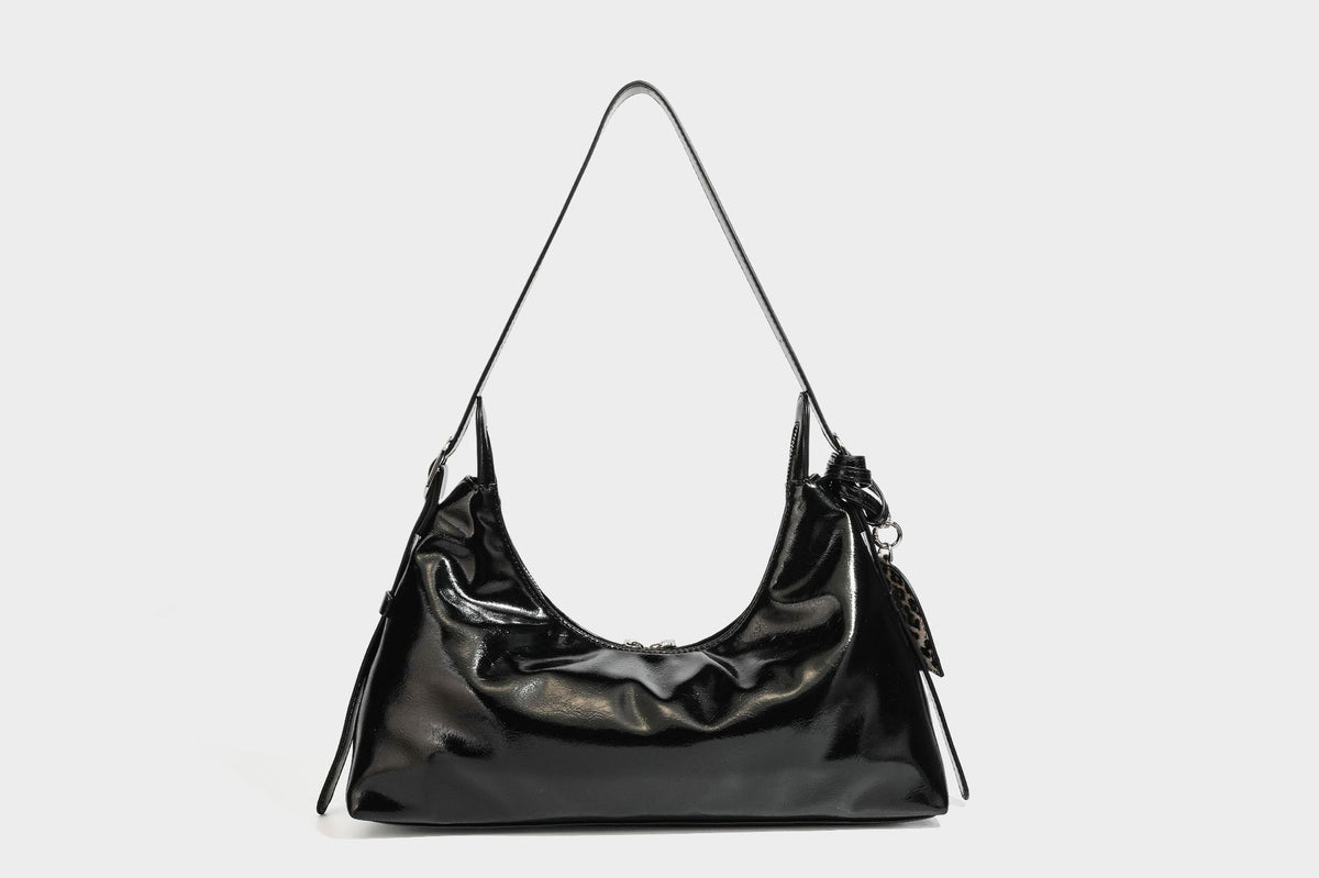 Glossy dark brown hobo shoulder bag with slim strap, front zip pocket, stud detail, and detachable leopard-print heart charm