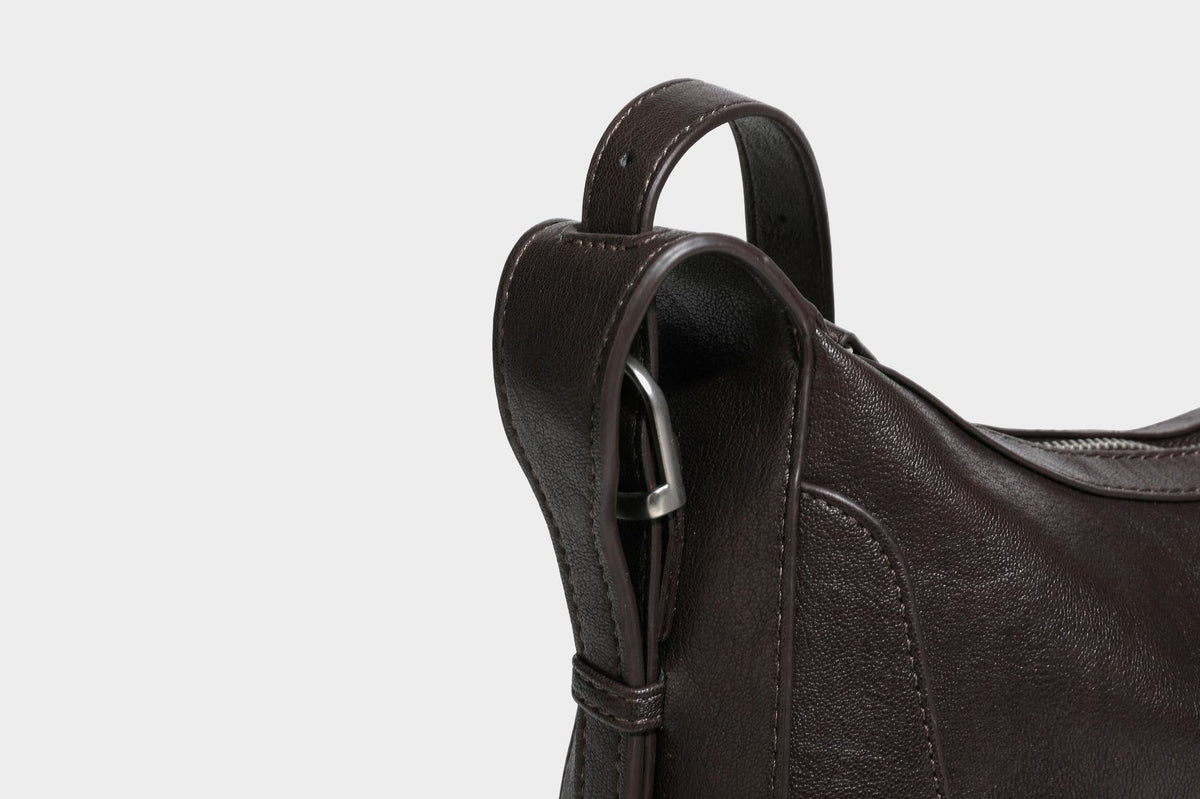 Slouchy crescent hobo shoulder bag in dark brown pebbled leather-look finish with zip top and long shoulder strap, detail