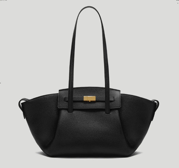 Black pebbled trapezoid tote bag with gold turn-lock hardware and double top handles, detail view 6