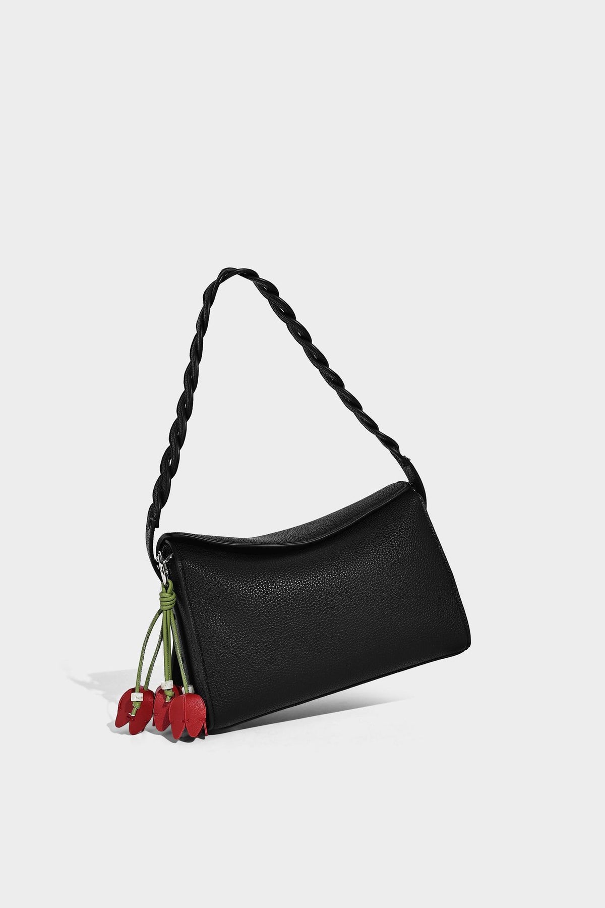 Small structured pebbled-finish shoulder bag with braided top handle, detachable crossbody strap, floral tassel charm, and