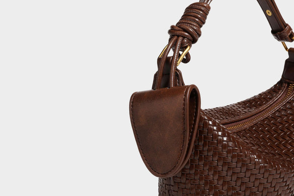 Small glossy basket-weave hobo shoulder bag in brown with knotted top handle, flap accent pocket, and gold-tone hardware