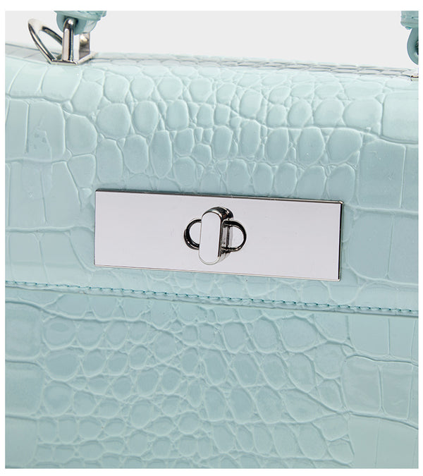 Small structured rectangular satchel with glossy crocodile-embossed finish, arched top handle, front flap, and silver-tone