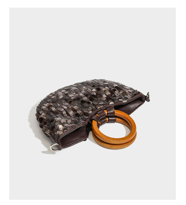 Small sequin half-moon handbag with circular wood-look ring handles and detachable leather-look shoulder strap, detail view