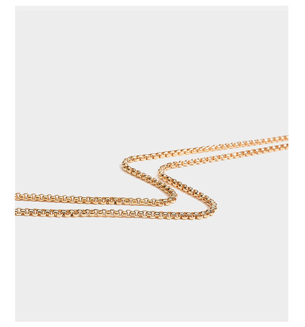 Structured rectangular metallic woven clutch bag with sculptural gold-tone leaf top handle and detachable chain strap, detail