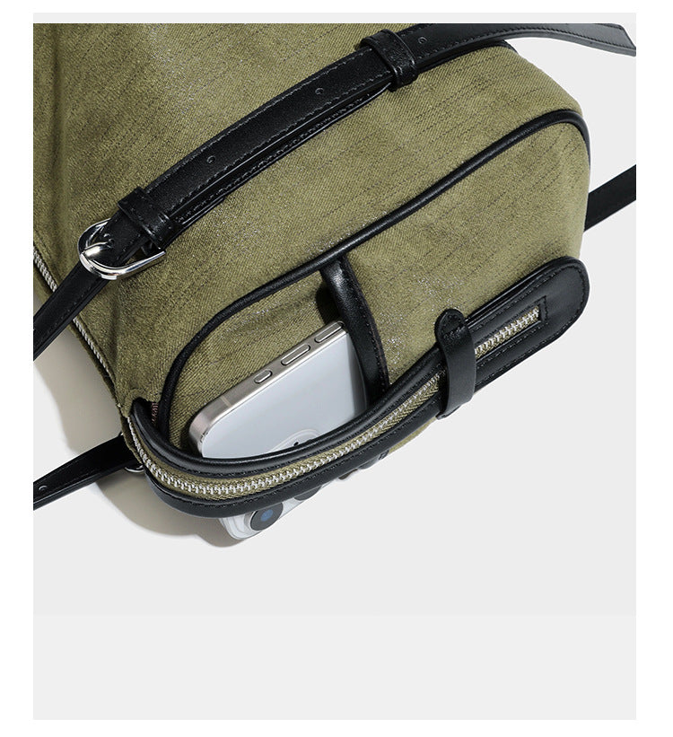 Olivgrüne Schultertasche in Zylinderform aus Canvas mit Riemen in schwarzer Lederoptik, Reißverschluss oben und silberfarbenen Beschlägen, Detailansicht