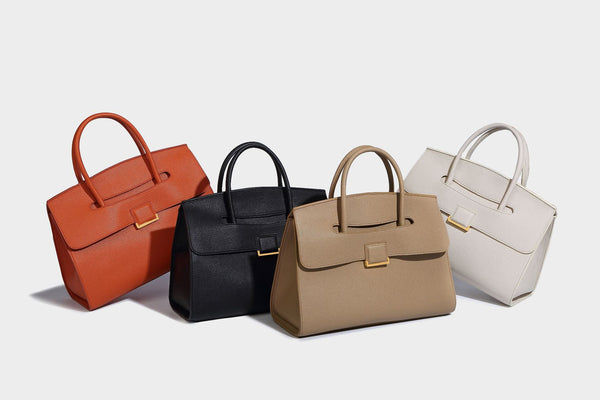 Strukturierte, trapezförmige Henkeltasche mit matt genarbter Oberfläche, vorderer Klappe und quadratischem Drehverschluss in Goldoptik, Detailansicht