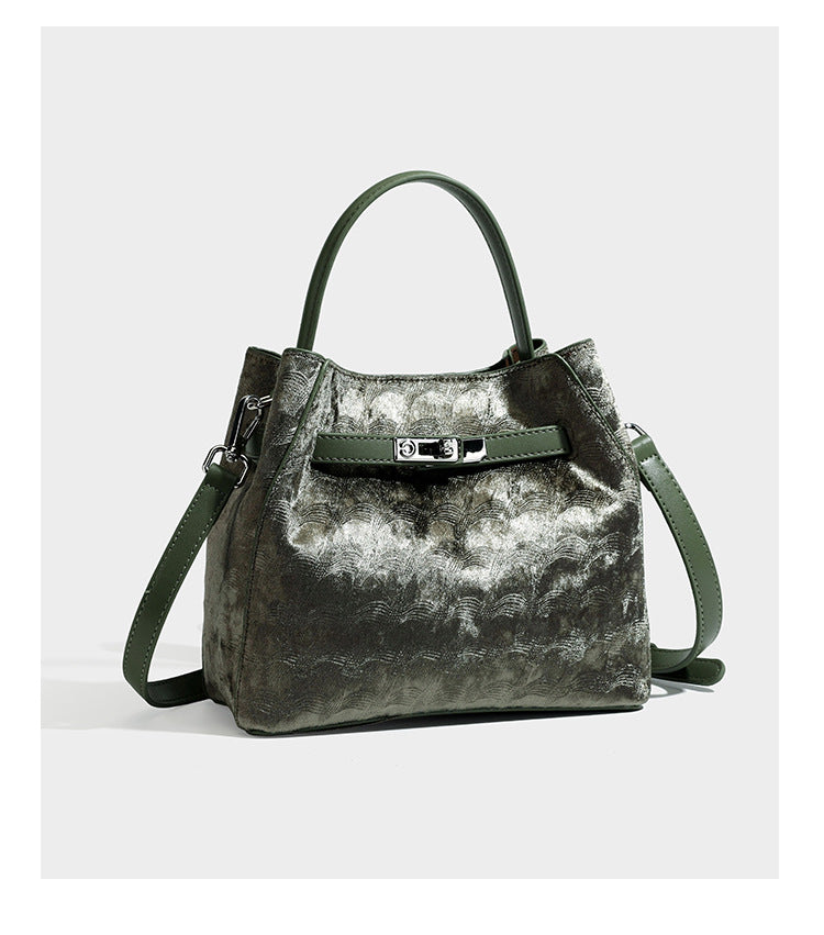 Small structured bucket satchel in embossed velvet-texture fabric with silver turn-lock hardware, rounded top handle, and