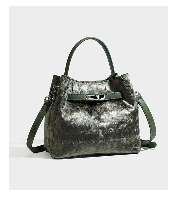 Small structured bucket satchel in embossed velvet-texture fabric with silver turn-lock hardware, rounded top handle, and