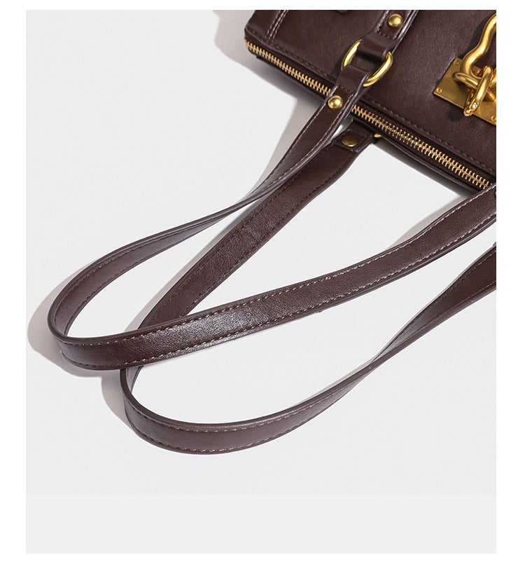 Strukturierte dunkelbraune Satchel-Tote in Lederoptik mit Ringverschluss in Antikgold-Optik, zwei Henkeln und seitlichem Riemen mit Schnalle