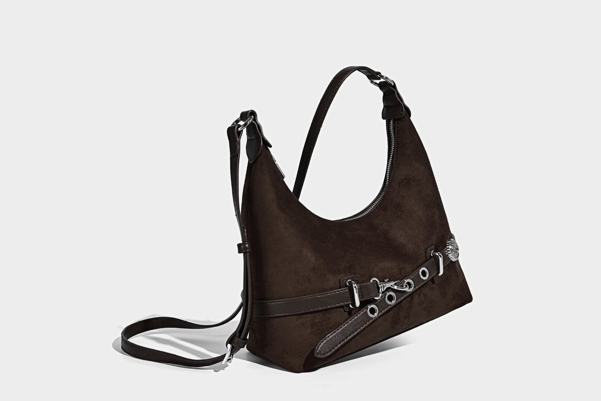 Hobo-Schultertasche in Dunkelbraun mit velourslederartiger Oberfläche, silberfarbener Gürtelschnalle und Ösenbeschlägen, verstellbarem Riemen, Detailansicht