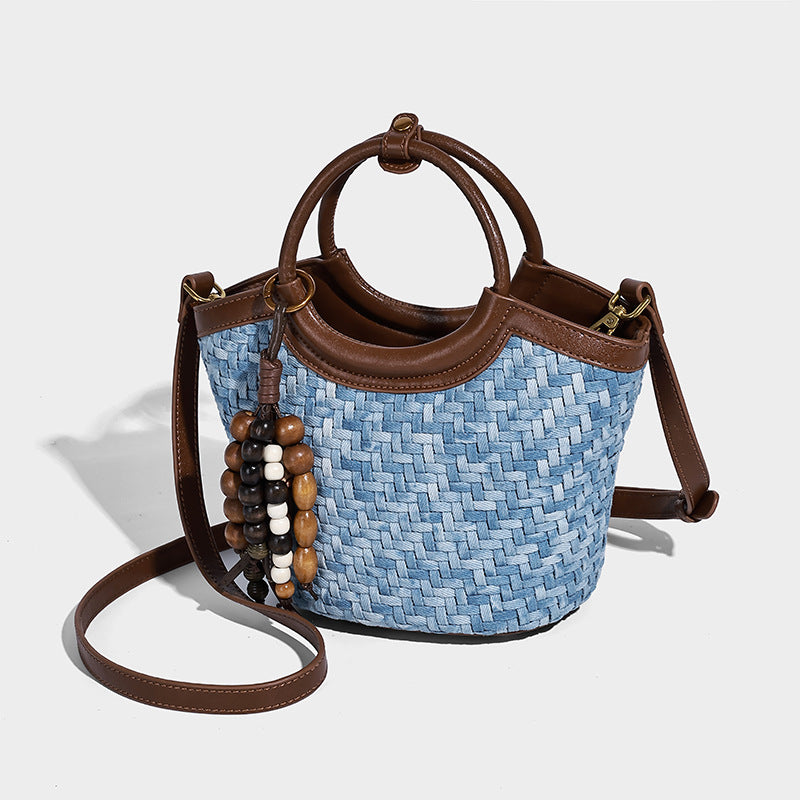 Blaue Bucket Bag in gewebter Denim-Optik mit brauner Besatz in Lederoptik, rundem Tragegriff, Quaste mit Holzperlen und verstellbar