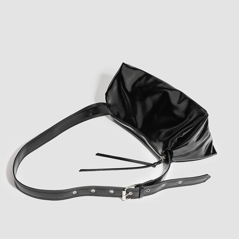 Black glossy leather-look slouchy shoulder bag with gathered top, zip tassel closure, and long adjustable silver-buckle