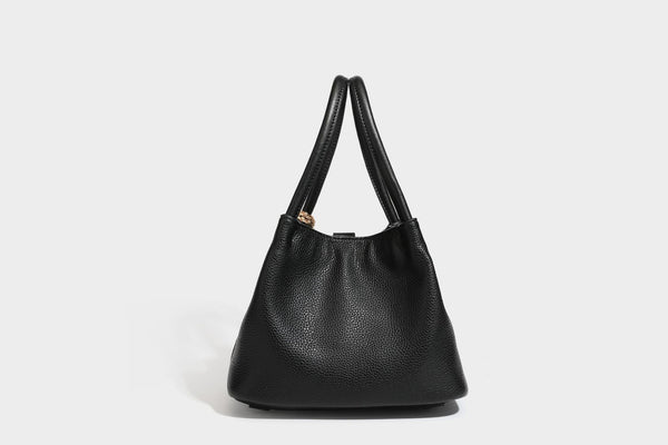 Pebbled leather-look bucket tote bag with rolled double handles, drawstring closure, braided cord charm, and detachable