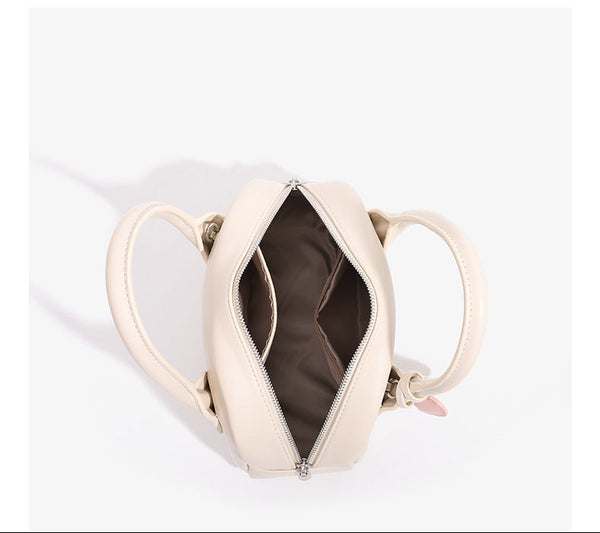 Mini-Handtasche in Kuppelform mit glatter Oberfläche in Lederoptik, zwei Henkeln, Reißverschluss oben, silberfarbenen Metalldetails und herabhängendem