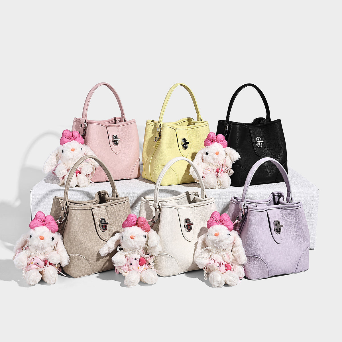 Small structured pebbled bucket bag with flap turn-lock closure, short top handle, and detachable shoulder strap, detail view