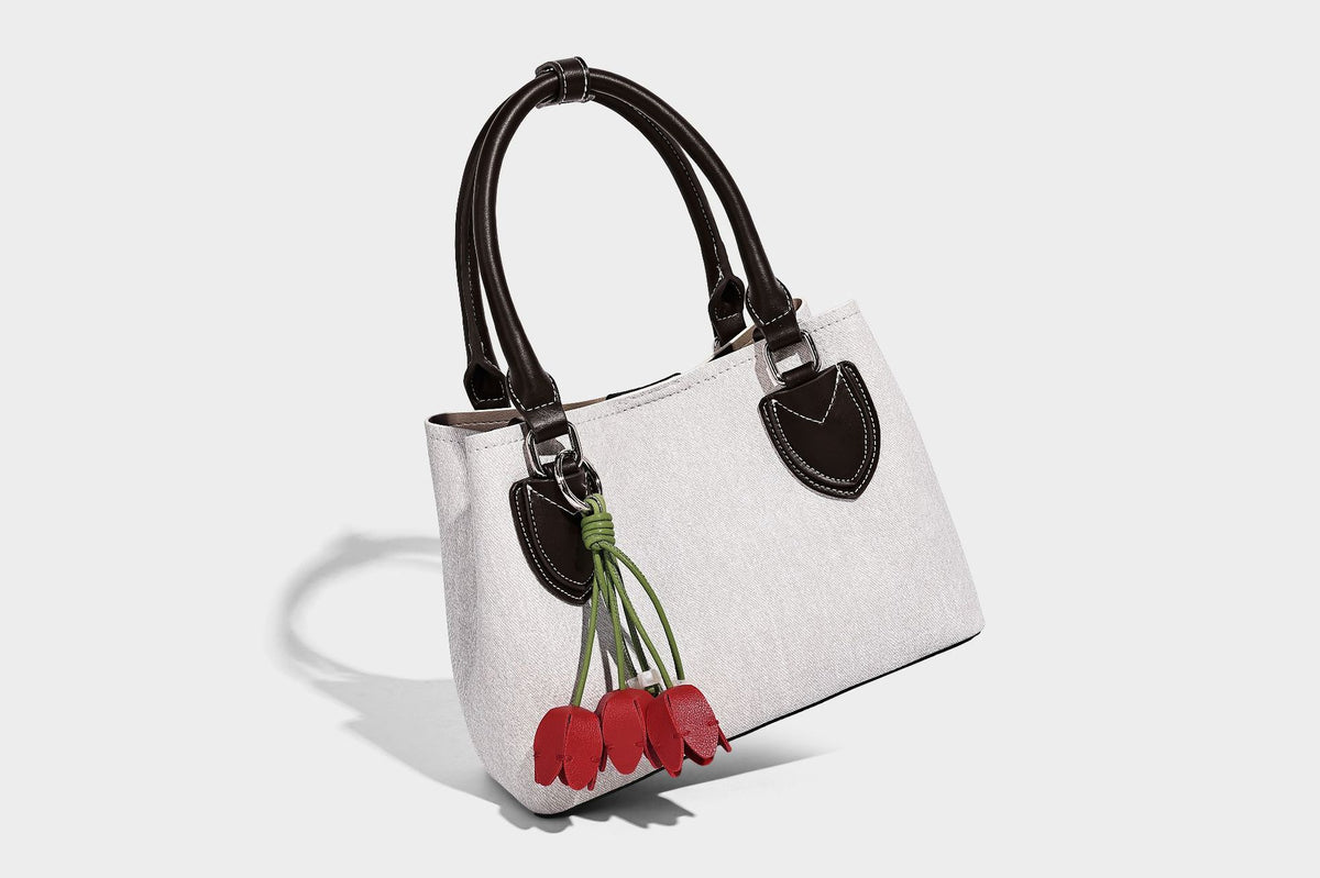 Structured light-blue denim-look tote bag with black leather-look handles, white contrast stitching, silver-tone hardware