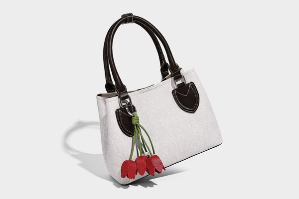 Structured light-blue denim-look tote bag with black leather-look handles, white contrast stitching, silver-tone hardware