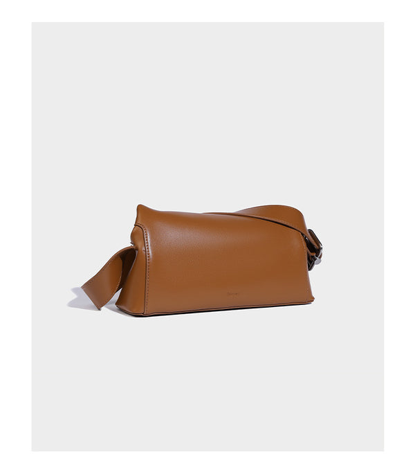 Compact structured baguette shoulder bag with smooth leather-look finish, zip top, and adjustable silver-buckle strap, detail