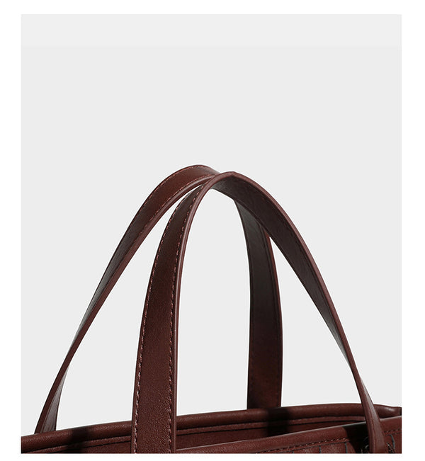 Strukturierte Tote-Bag in Dunkelbraun mit gewebter Reliefstruktur in Lederoptik, zwei Tragegriffen, abnehmbarem Crossbody-Riemen und rund