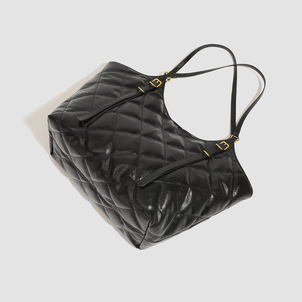 Large quilted diamond-pattern tote bag with glossy leather-look finish, dual flat shoulder straps, and gold-tone hardware
