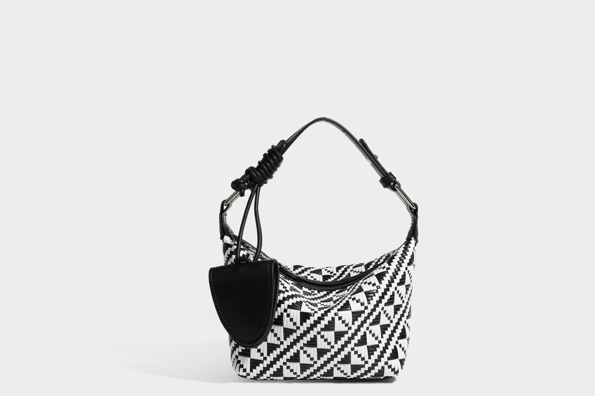 Kleine gewebte geometrische Schultertasche in Schwarz und Weiß mit glattem Besatz in dunkelbrauner Lederoptik, verstellbarem Knotenriemen, Seitenansicht