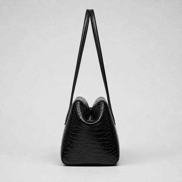 Schwarze glänzende Schultertasche in Trapezform mit Krokoprägung, zwei abgerundeten Riemen und Reißverschluss, Detailansicht 14