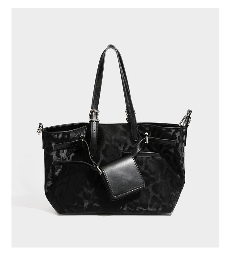 Glossy leopard-print tote bag with leather-look dark trim, dual top handles, detachable shoulder strap, and attached front