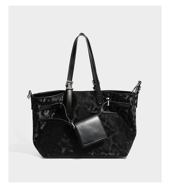 Glossy leopard-print tote bag with leather-look dark trim, dual top handles, detachable shoulder strap, and attached front