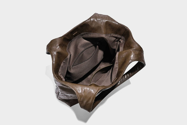 Large open-top tote bag with crinkled leather-look finish, long double shoulder straps, and embossed circular detail on