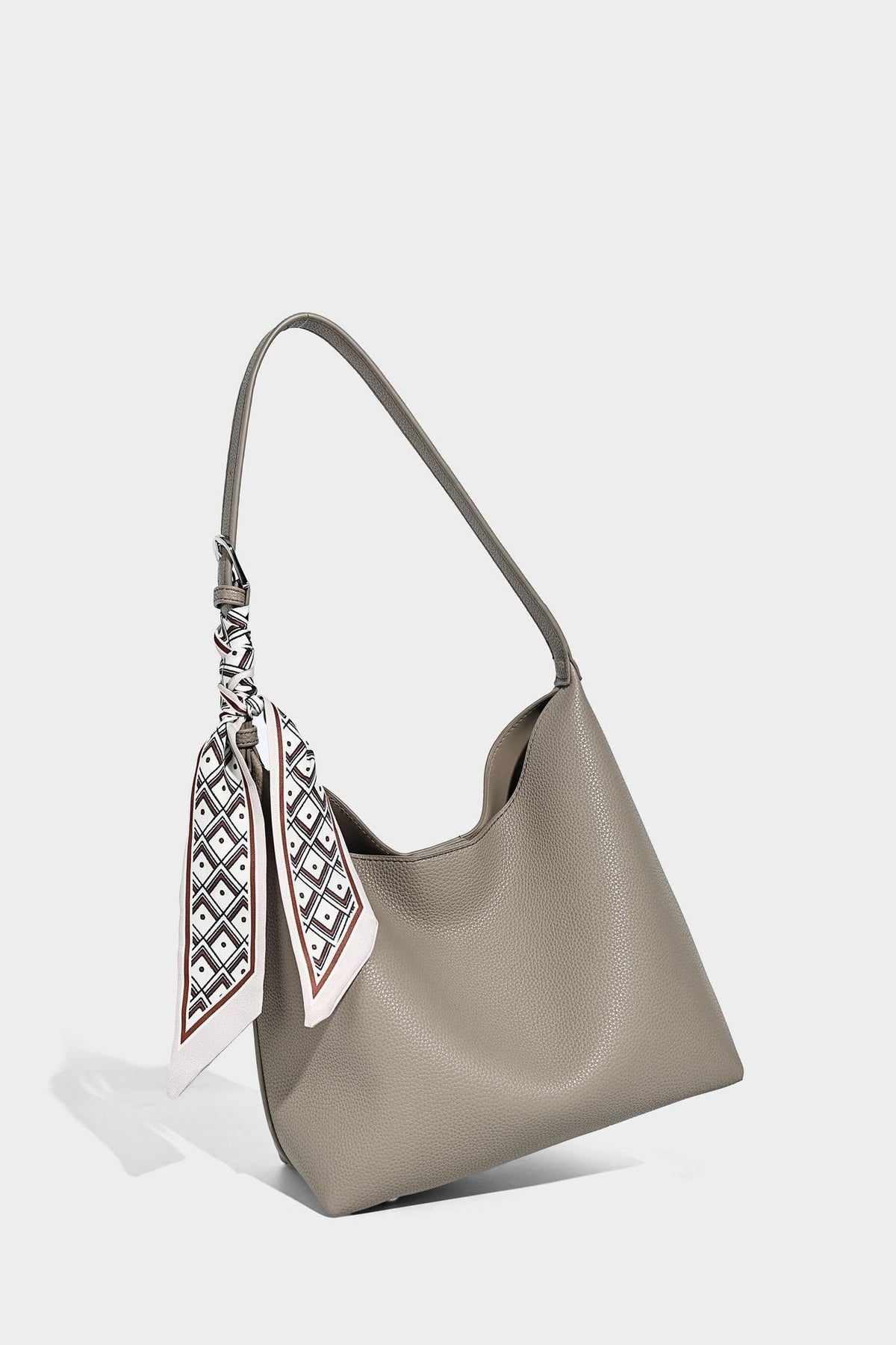 Soft slouchy hobo shoulder bag in pebbled matte finish with slim strap, silver-tone ring hardware, and knotted printed scarf