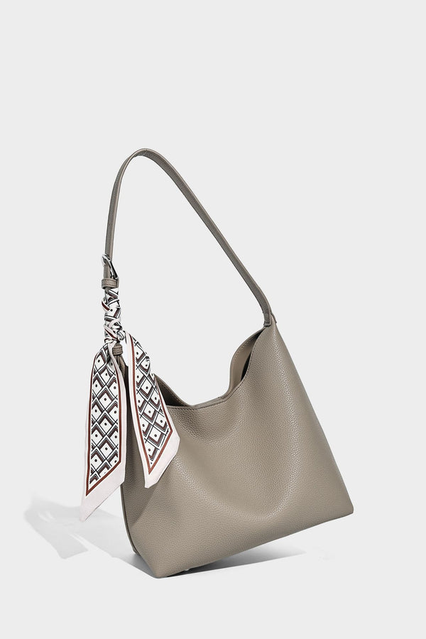 Soft slouchy hobo shoulder bag in pebbled matte finish with slim strap, silver-tone ring hardware, and knotted printed scarf