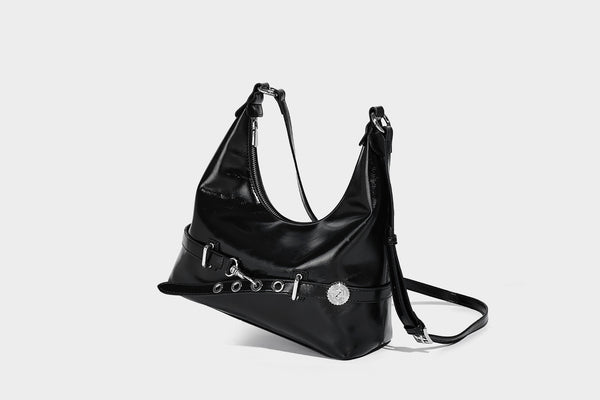 Glossy black slouchy hobo shoulder bag with silver-tone hardware, belt-style grommet strap at base, and long adjustable