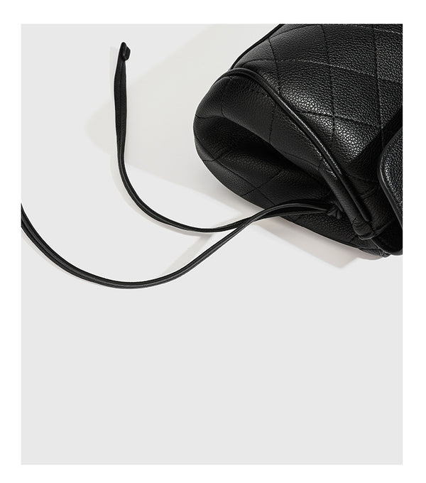 Structured black diamond-quilted shoulder bag with gold-tone turn-lock flap closure and dual round shoulder straps, detail