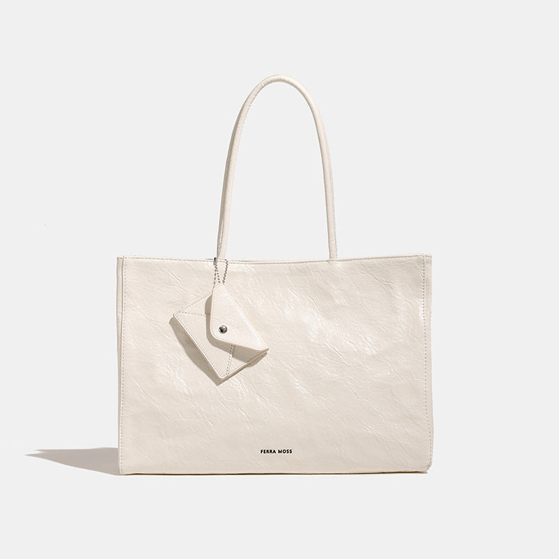 Large glossy crinkled rectangular tote bag with long double handles and hanging envelope snap tag, detail view 7