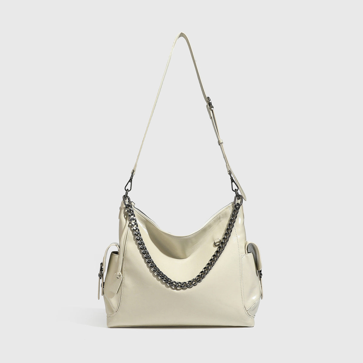 Slouchy hobo shoulder bag with glossy leather-look finish, silver-tone chain drape across front, side buckle pockets, and