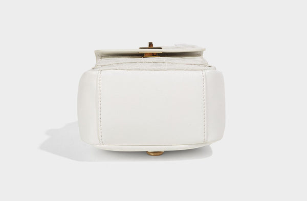 Structured mini backpack handbag with butterfly embroidery, gold-tone chain strap, and turn-lock front flap pocket, detail