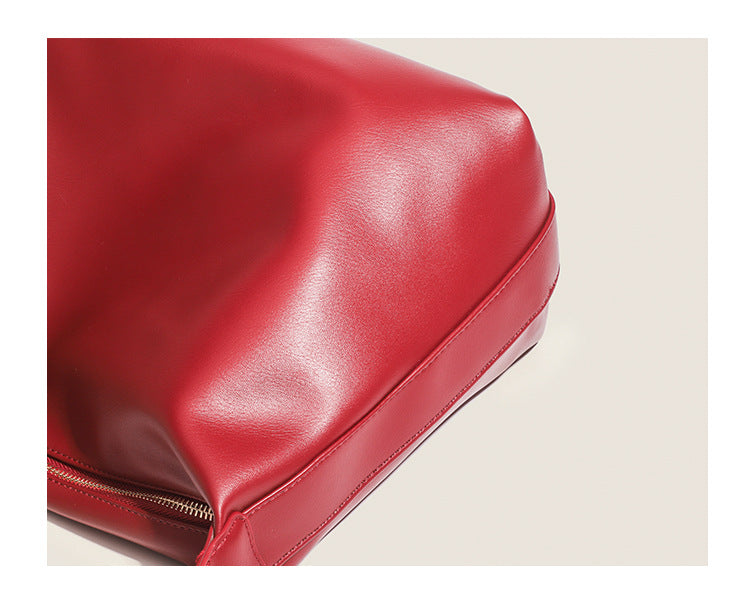 Large slouchy hobo shoulder bag in smooth leather-look finish with single long strap and gold-tone zip closure, detail view