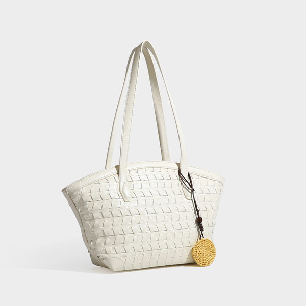 Large leather-look tote bag with geometric woven emboss, double shoulder straps, and round woven cord charm in brown, detail