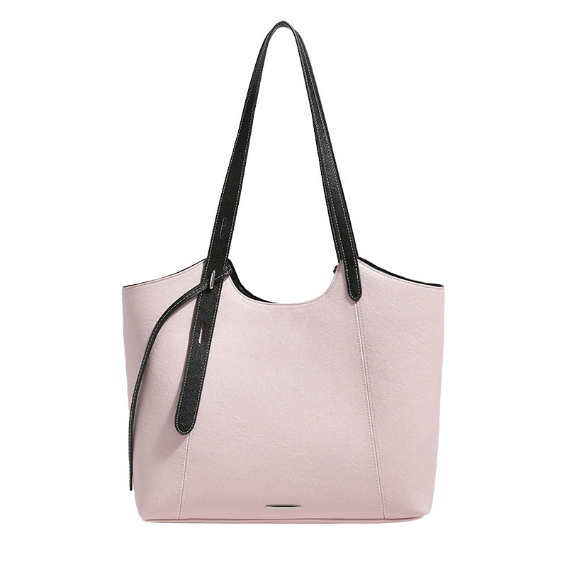 Structured trapezoidal tote bag with smooth leather-look finish, long black contrast shoulder straps, and dangling strap