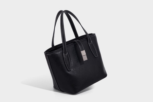 Compact structured bucket tote bag with pebbled textured finish, dual top handles, silver-tone lock hardware, and detachable