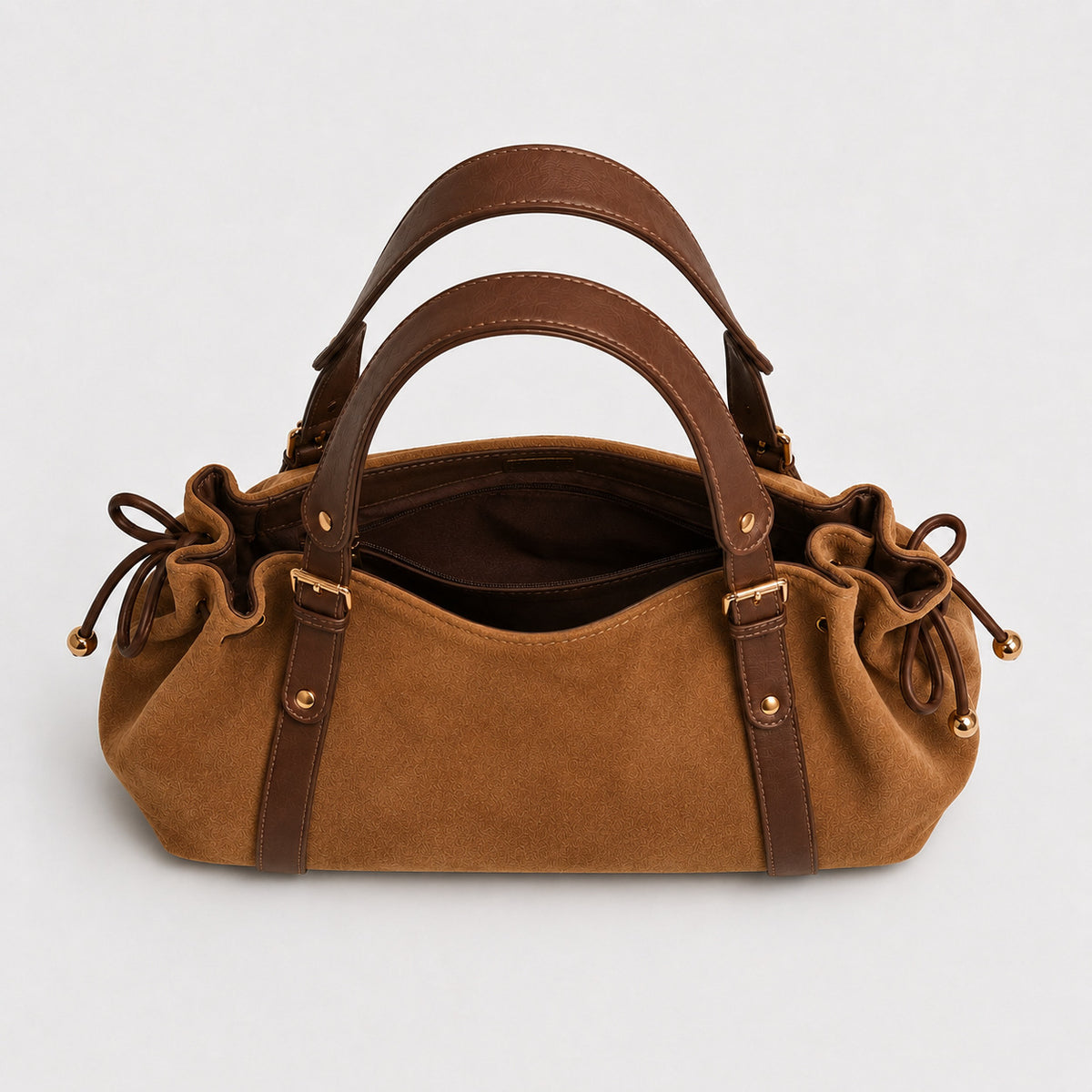 Soft suede-texture shoulder bag in brown with drawstring sides, leather-look vertical straps, gold-tone buckle hardware, and