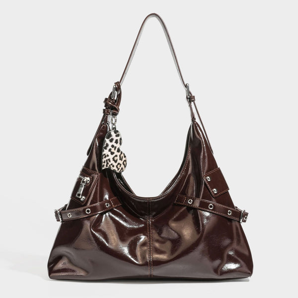 Glänzende dunkelbraune, lässig geschnittene Hobo-Schultertasche mit Riemendetail mit silberfarbenen Ösen, Reißverschlussfach auf der Vorderseite und Herz mit Leopardenmuster