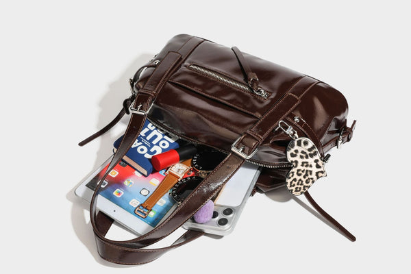 Strukturierte Schultertasche in glänzender Lederoptik mit abgerundetem Korpus, silberfarbenen Beschlägen, Reißverschlussfach auf der Vorderseite und Leopardenmuster
