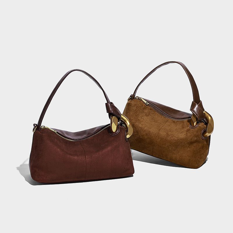 Kompakte Boston-Schultertasche in warmer, brauner Veloursleder-Optik mit glattem dunkelbraunem Besatz, übergroßem goldfarbenem Ringbeschlag und Reißverschluss oben