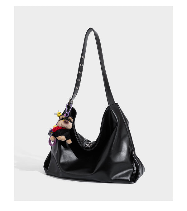 Große schwarze, weich fallende Hobo-Schultertasche in glänzender Lederoptik mit mit Ösen besetztem Riemen, silberfarbenen Metallbeschlägen und abnehmbarem