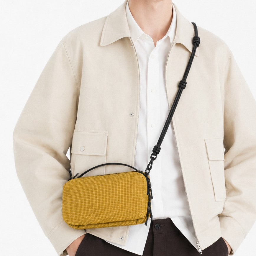 Compact rectangular zip-top nylon crossbody bag with knotted adjustable strap and short top handle, detail view 2