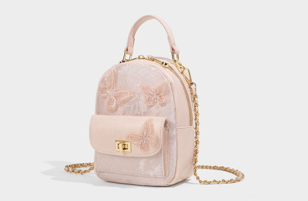 Structured mini backpack handbag with butterfly embroidery, gold-tone chain strap, and turn-lock front flap pocket, detail