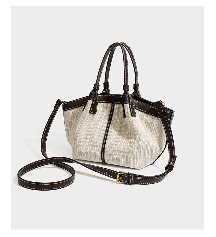 Cremefarbene geflochtene Tote-Bag mit dunkelbraunen Besätzen in Lederoptik, kontrastierenden weißen Nähten, zwei oberen Henkeln und abnehmbarem Schulter